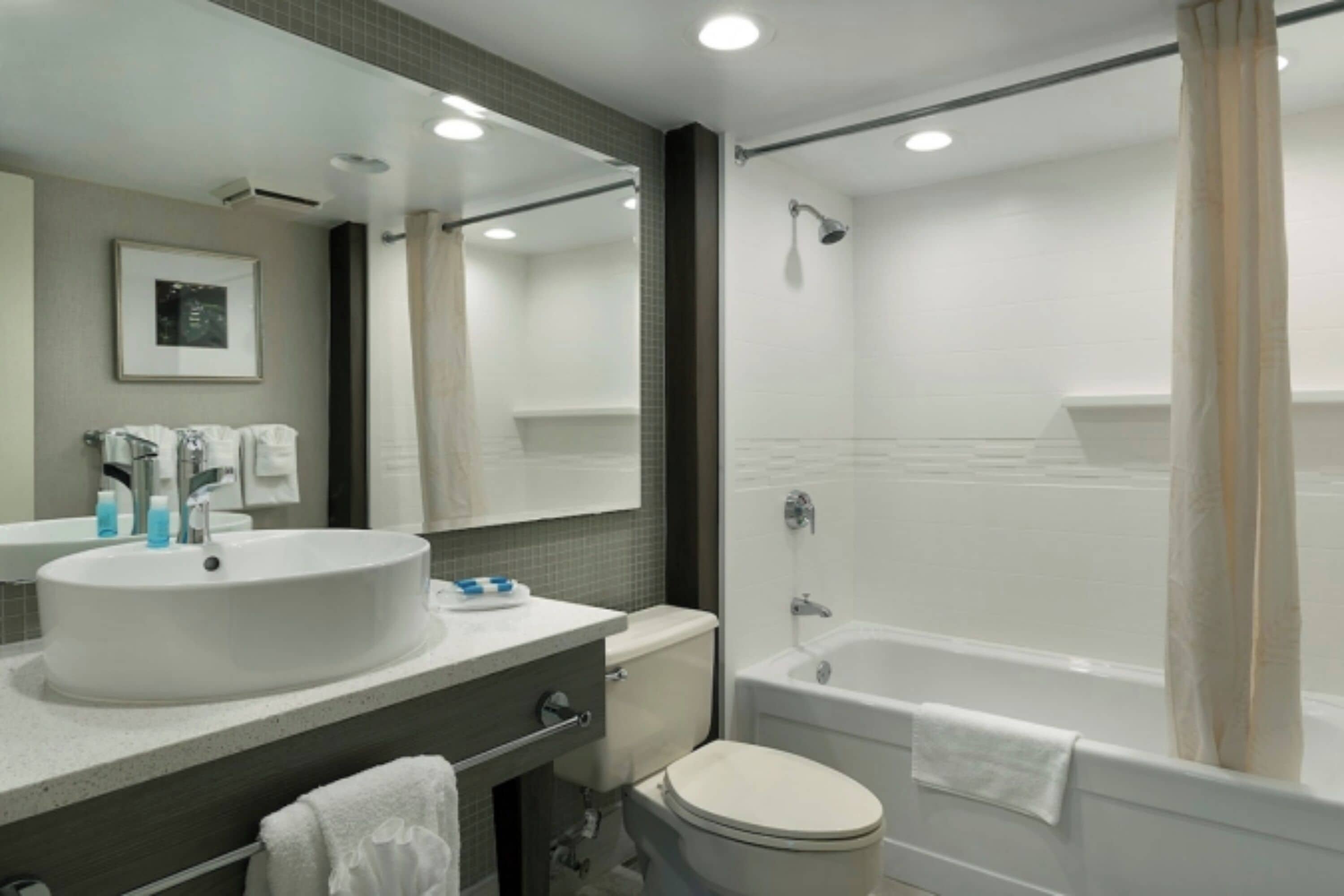 A modern bathroom with a large sink, toilet, and bathtub.