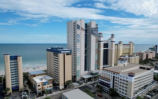 Un hotel con vista al mar, varios pisos y un cartel que dice 'Courtyard by Marriott'.