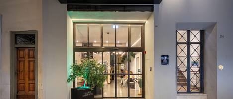 The exterior of the Globus Urban Hotel with a modern entrance, a sign above the door, and a potted plant in front.