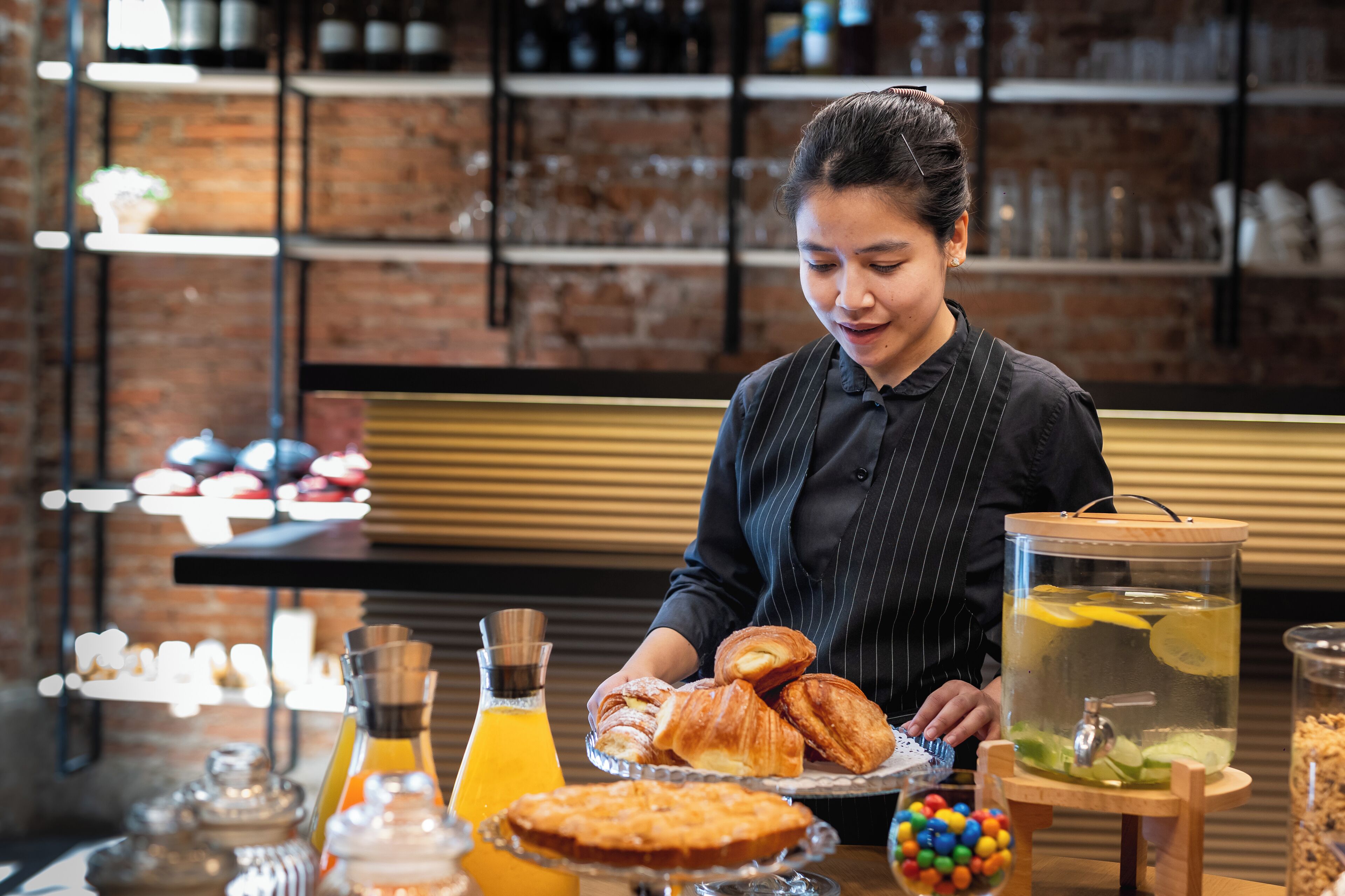 A breakfast setting with pastries, a fruit drink, and a decorative container.