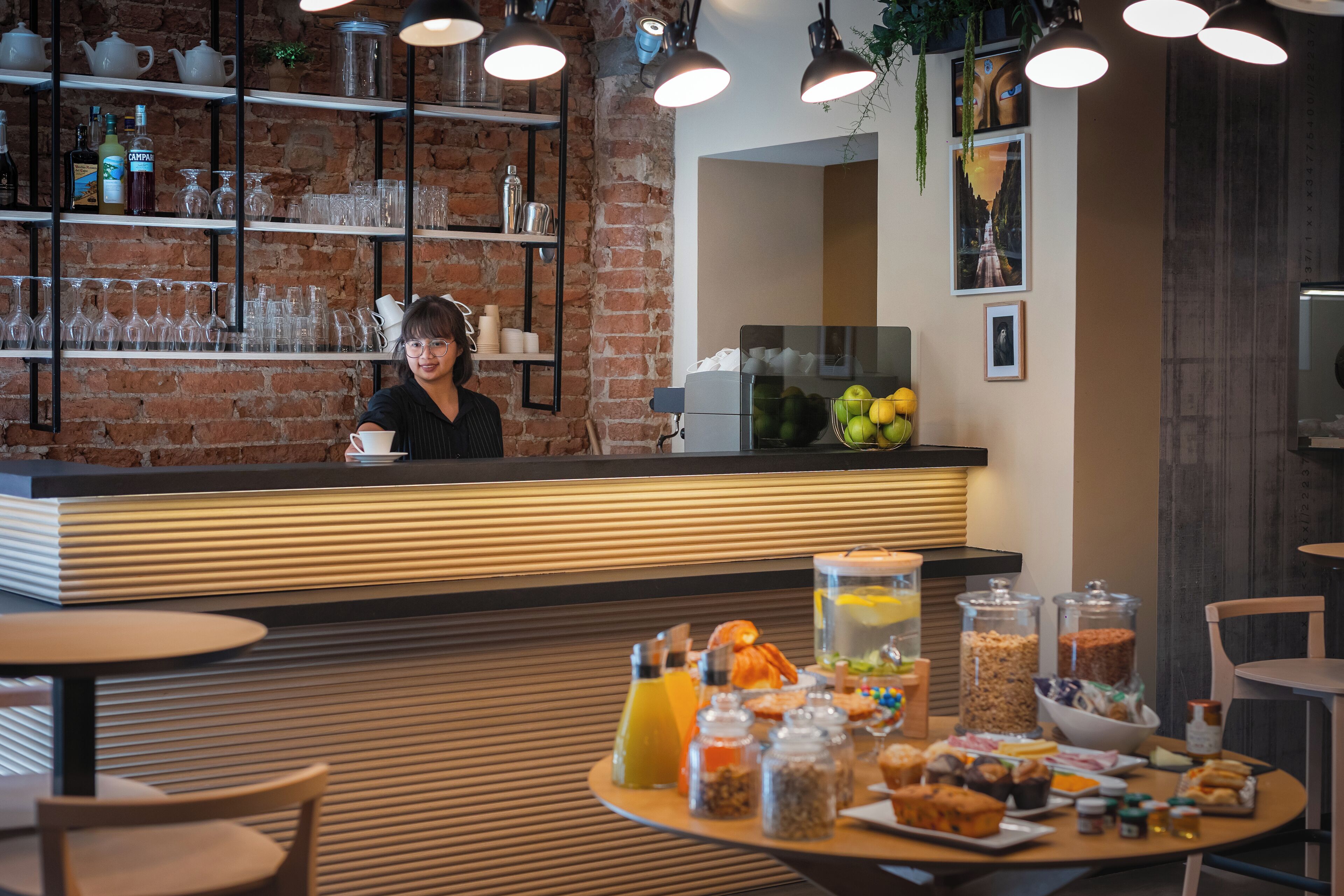 A breakfast buffet with various food items and a bar area with shelves of glassware and bottles.