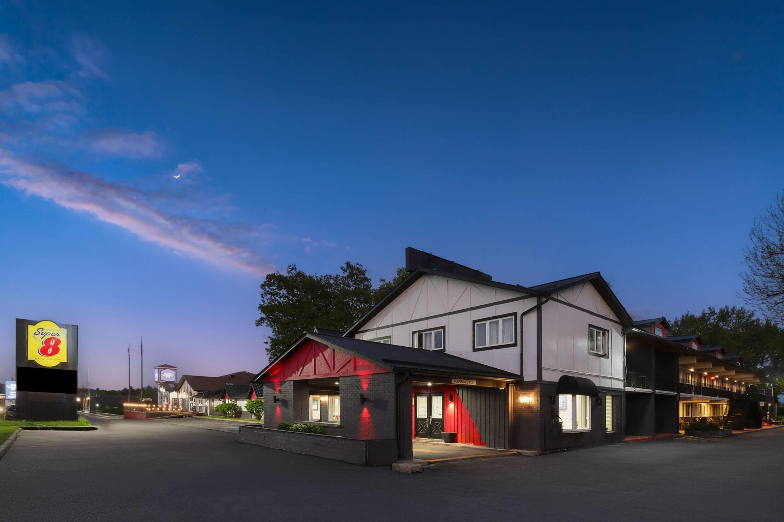 A hotel with a prominent sign, a main building, and a smaller annex.