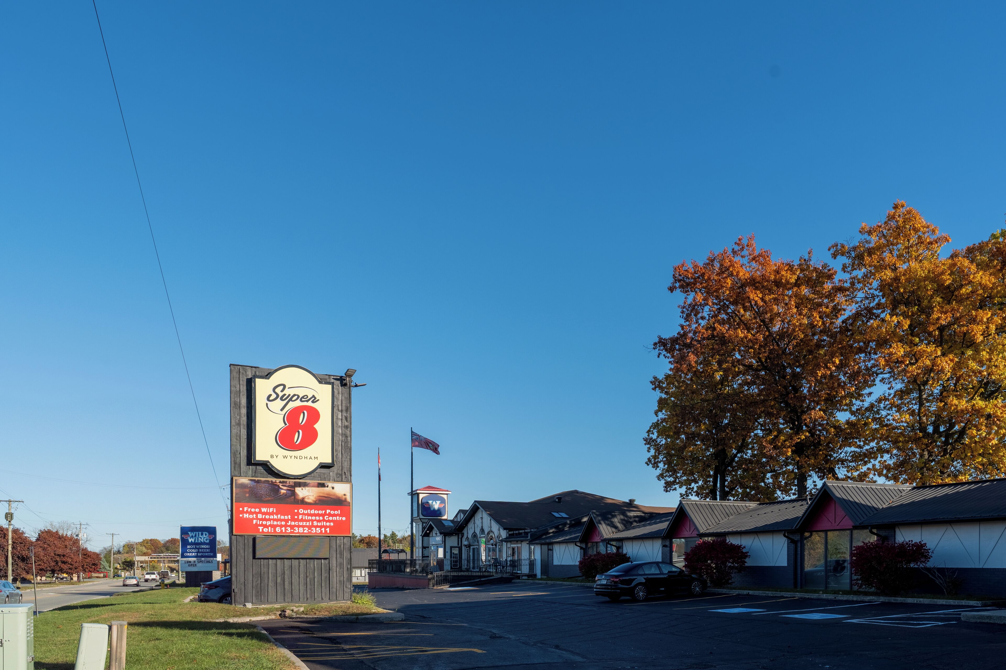 A Super 8 motel with a large sign, outdoor seating, and a flag.