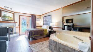A hotel room with a large bed, a sitting area with a chair, a bathtub, a television, and a large window with curtains. - Super 8 by Wyndham Gananoque/Country Squire Resort (Gananoque)