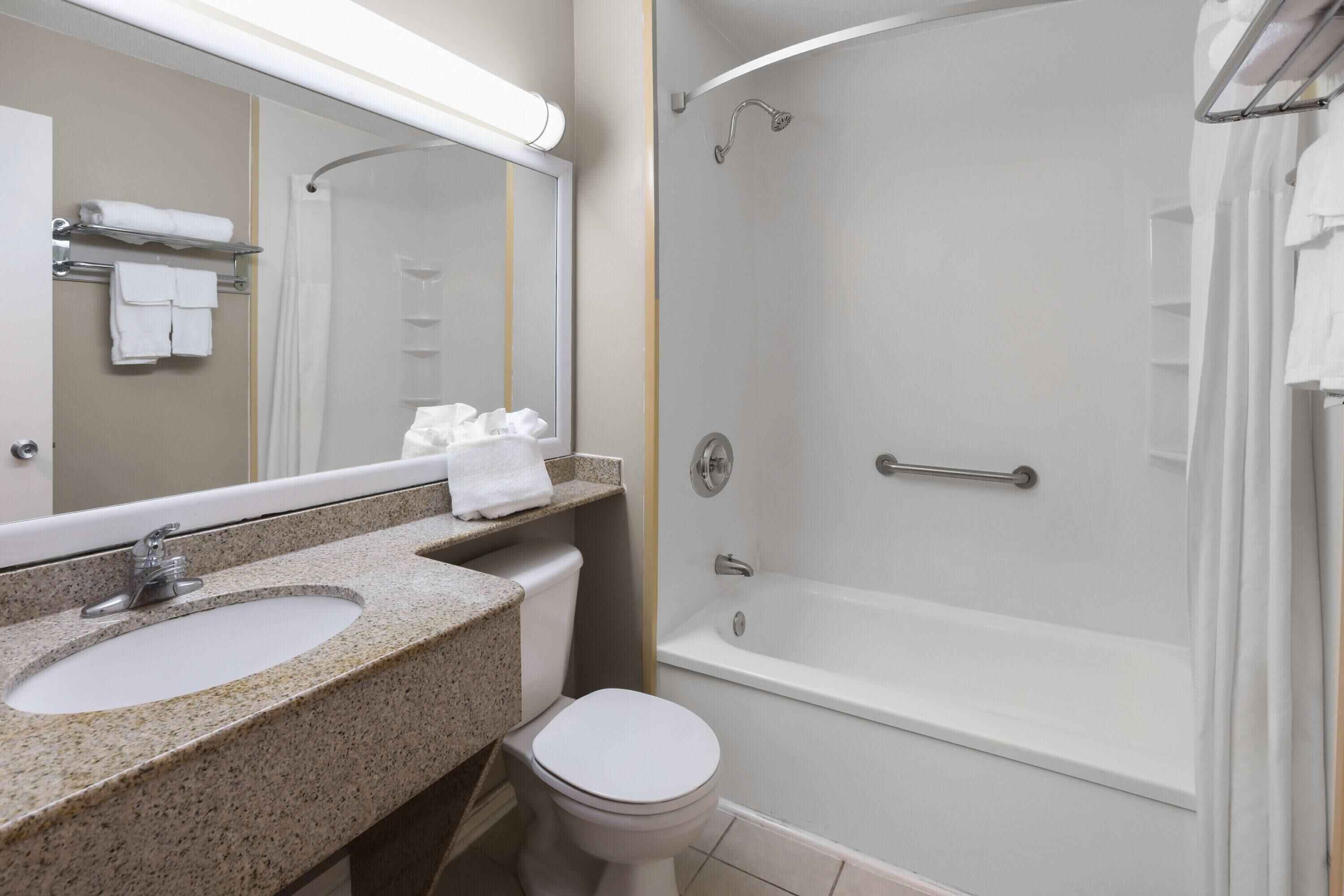 A bathroom with a sink, toilet, and shower.