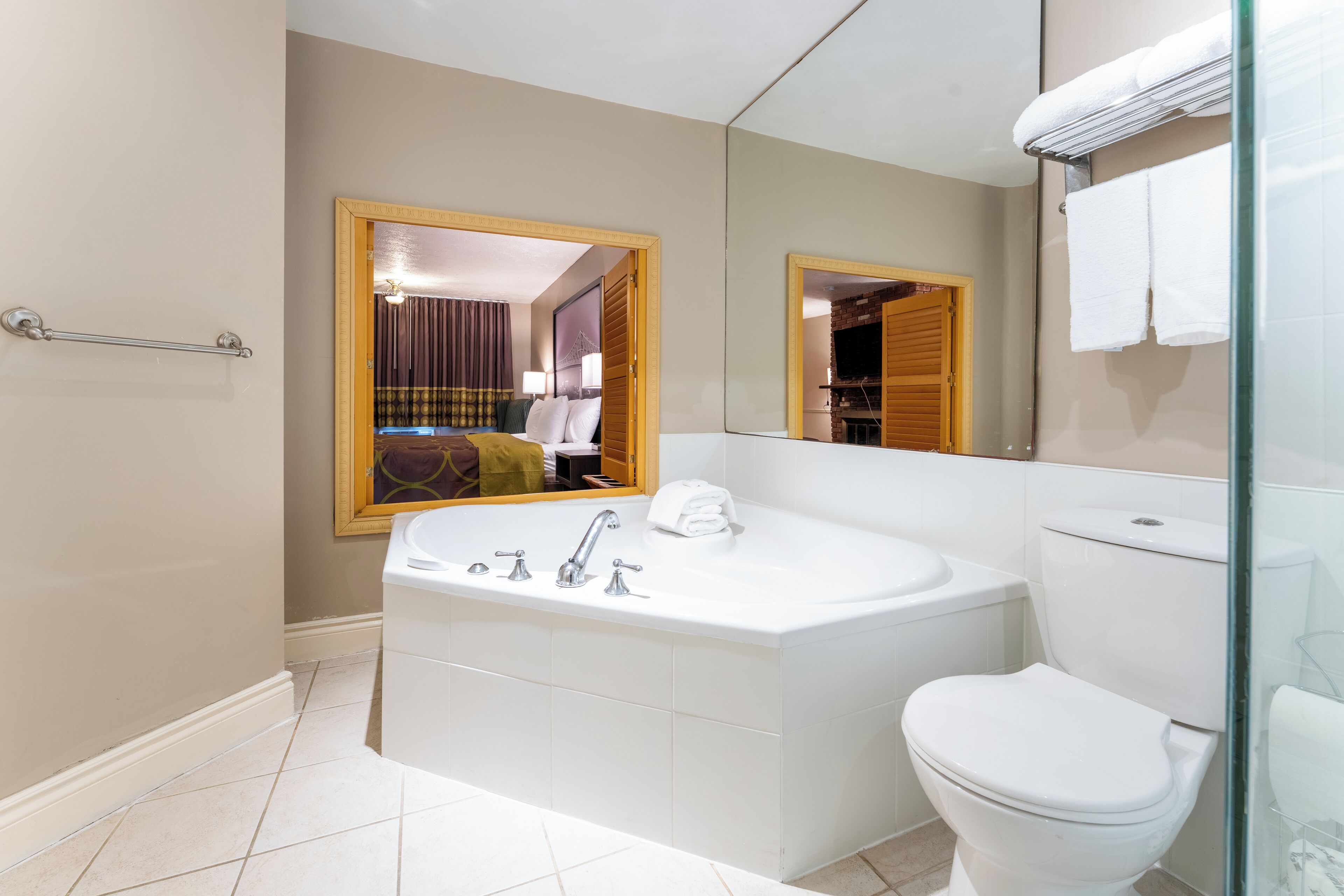 Un baño moderno con una bañera grande, un inodoro y una mampara de cristal.