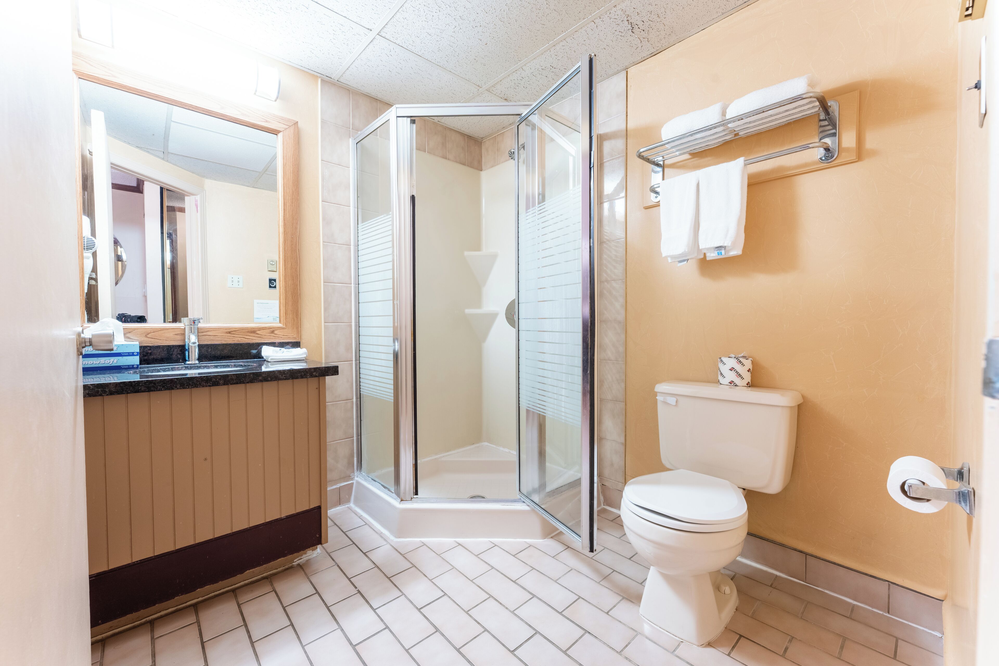 Een moderne badkamer met een douchecabine van glas, een toilet en een wastafel met spiegel.