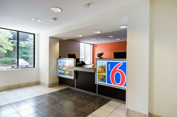 Welcome to our reception area, featuring a spacious desk with a view of the outdoors through the large window.