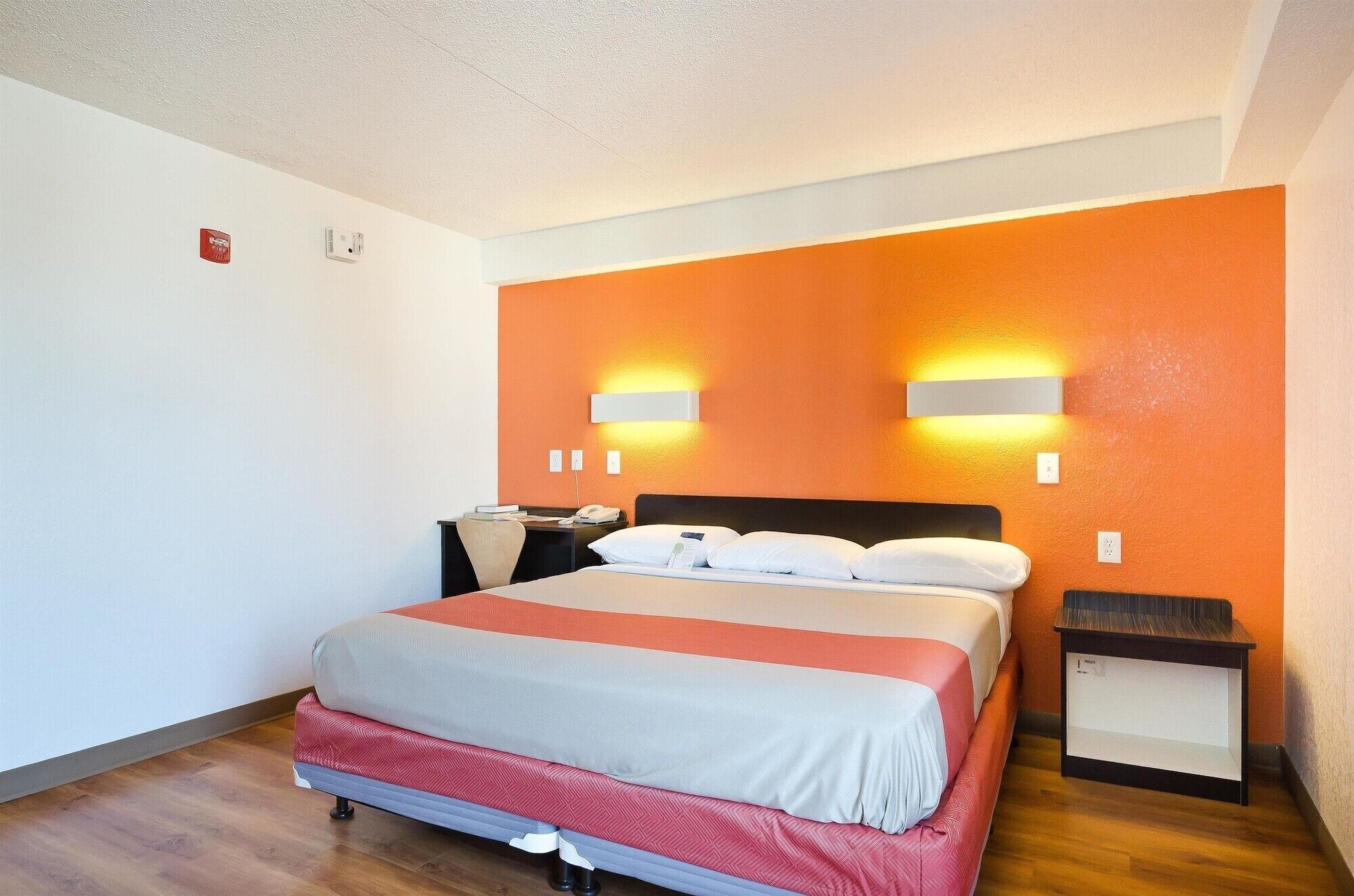 Una camera d'albergo con un letto, comodini e una scrivania.
