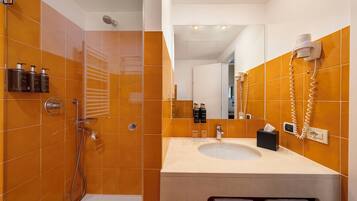 Une salle de bain moderne avec des carreaux orange, une douche, un lavabo et un miroir.