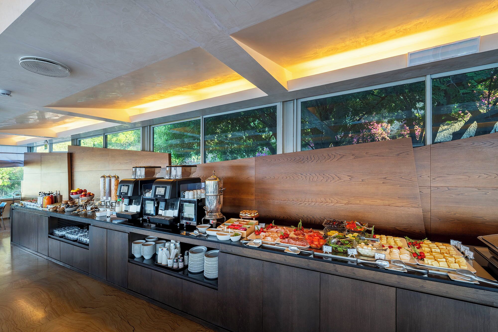 A buffet setup with coffee machines and a variety of food items.