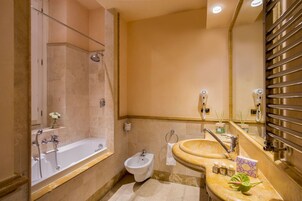 A bathroom with a bathtub, bidet, and sink.