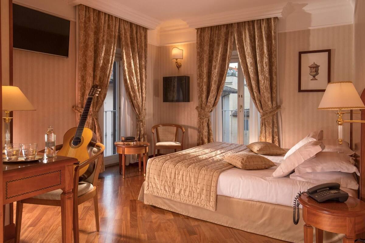 أغطية فراش متميزة وميني بار وخزنة داخل الغرفة ومكتب