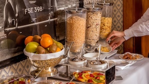 Disposição de buffet com diversos alimentos e recipientes.