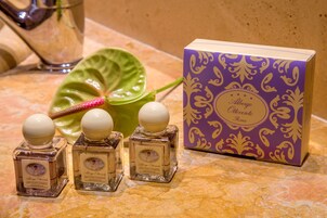 Three bottles of bath foam and shampoo, a decorative leaf, and a purple box with a floral pattern.