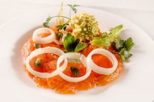 A plate of smoked salmon with garnishes.