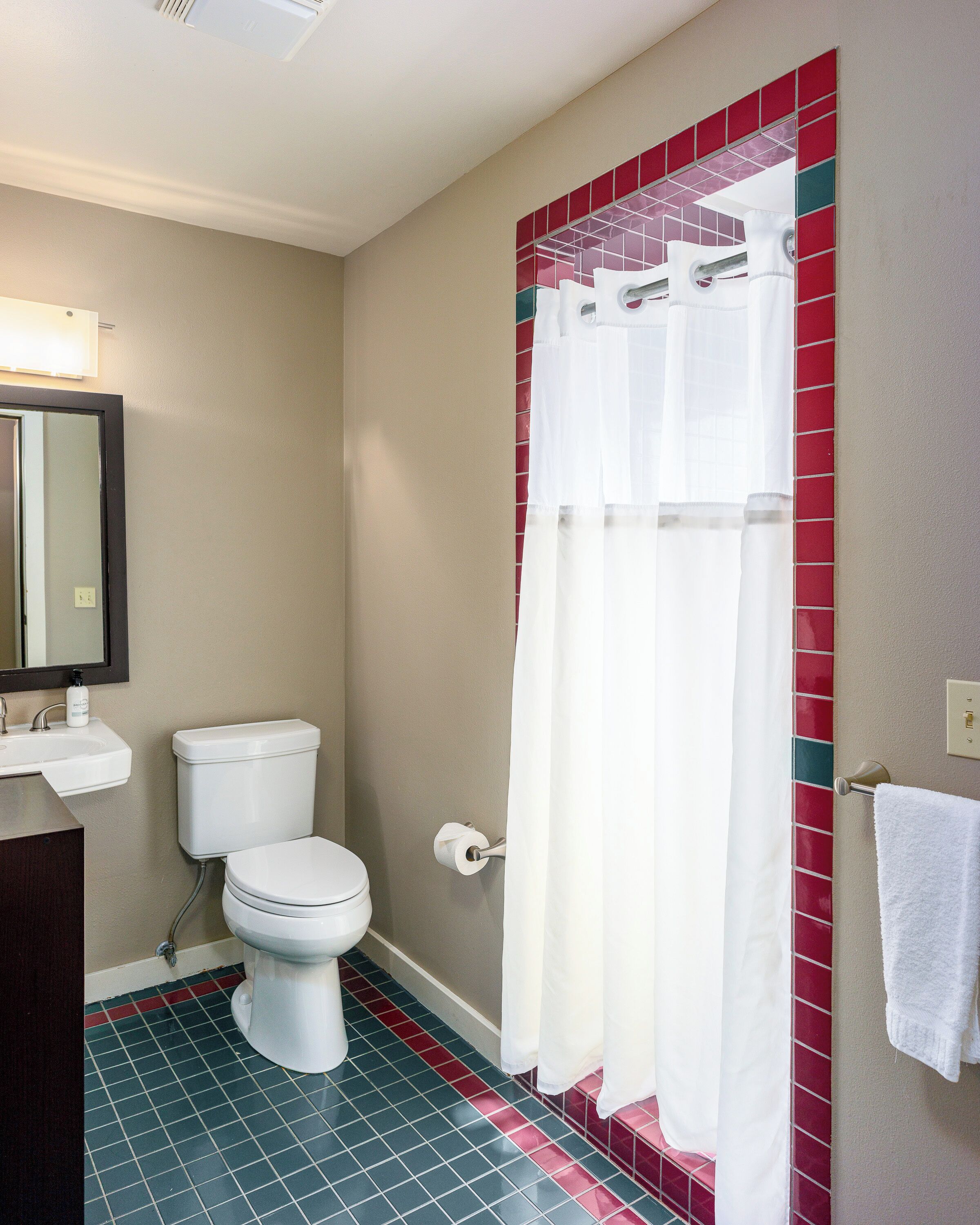 A bathroom with a toilet, sink, and shower curtain.
