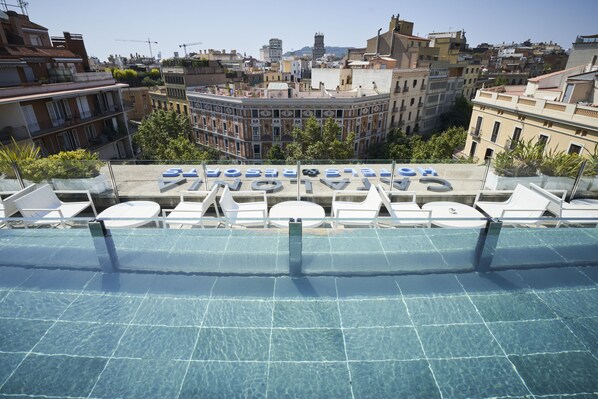 Una piscina al aire libre, tumbonas