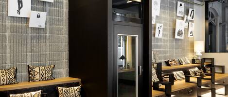 A modern lobby with a seating area, a reception desk, and artwork on the walls.