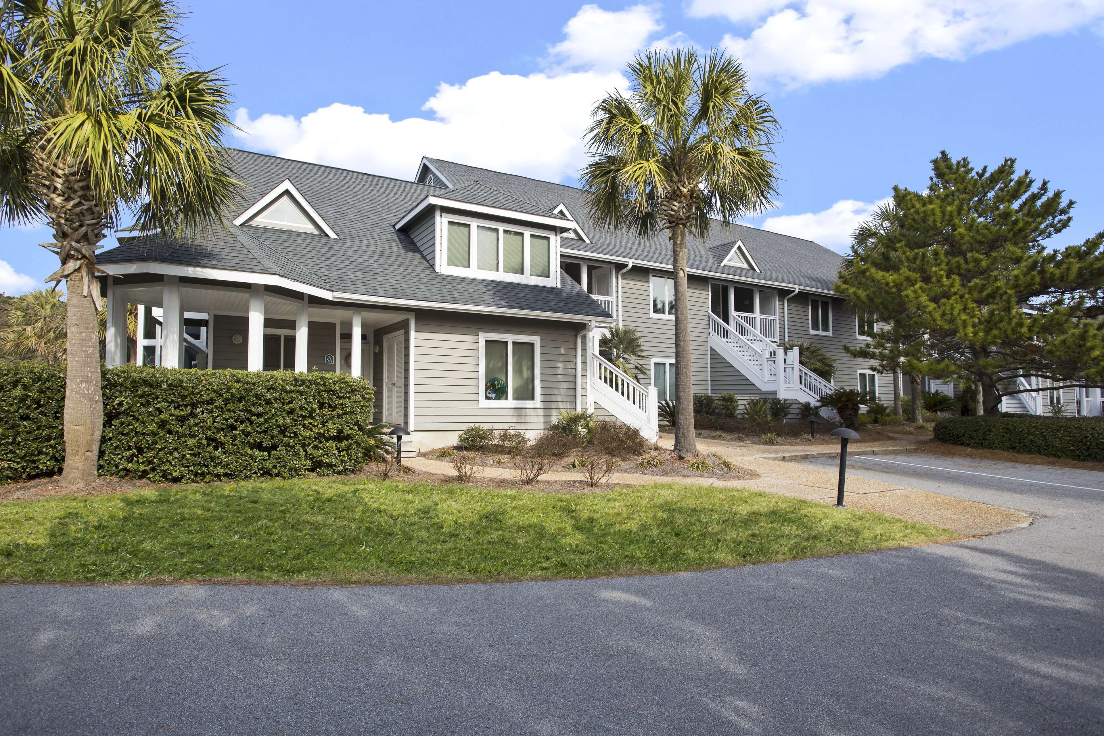 A two-story house with a covered porch, a staircase, and a well-maintained lawn.