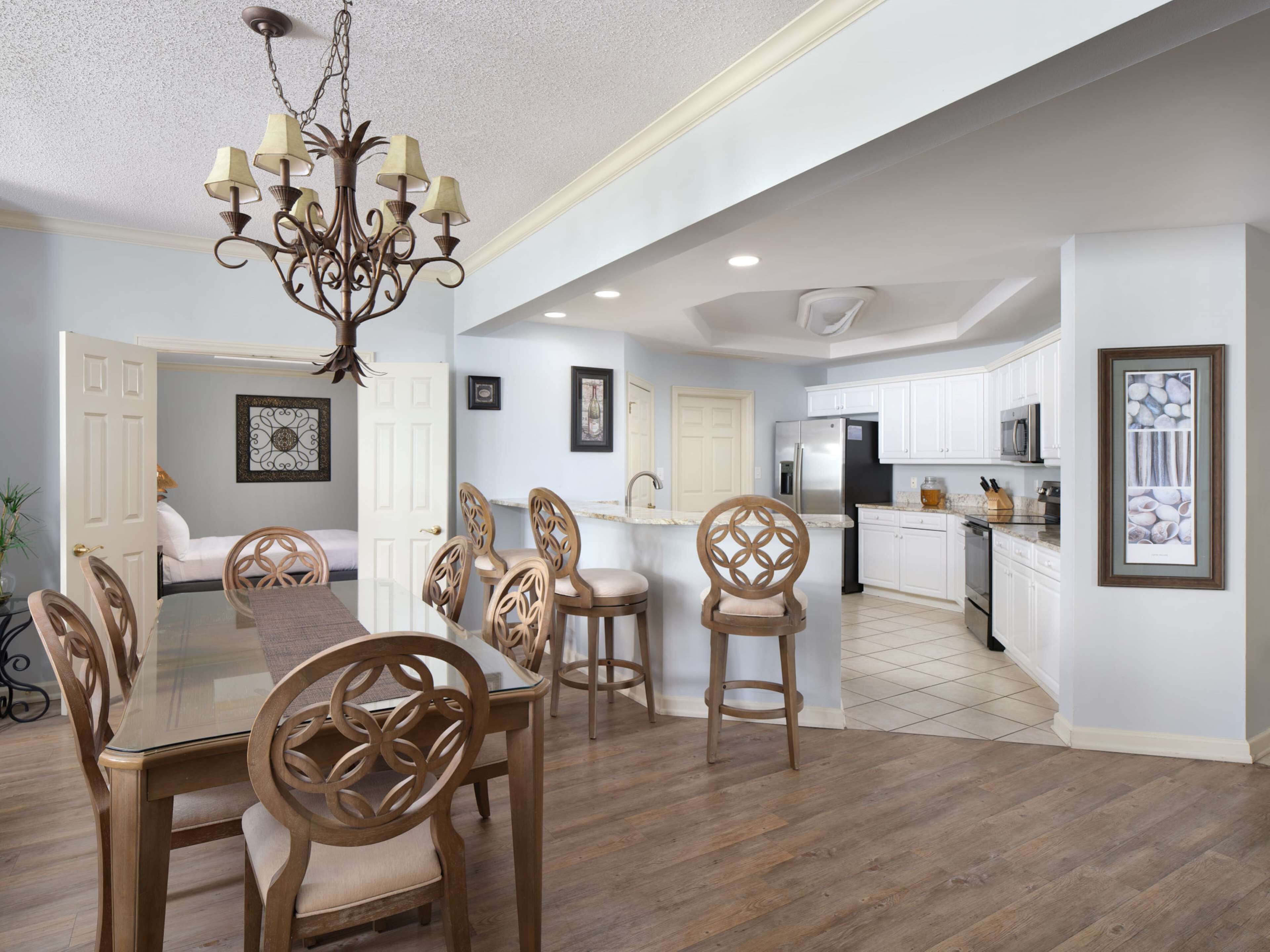 A spacious kitchen with white cabinets, a stainless steel refrigerator, and a microwave.