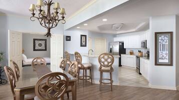 A spacious kitchen with white cabinets, a stainless steel refrigerator, and a microwave.