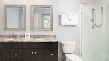 A bathroom with dark wooden cabinets, a white toilet, and a glass-enclosed shower.