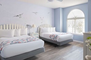 A bedroom with two beds, a white picket fence headboard, a window with blinds, and a wall mural of birds. - Kingston Plantation Condos (Myrtle Beach)