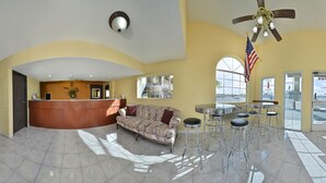A spacious lobby with a reception desk, a sofa, and a bar area with stools. - Days Inn by Wyndham El Centro (El Centro)