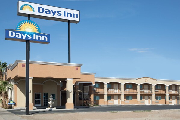 Edificio Days Inn con cielo sereno, insegna e parcheggio.