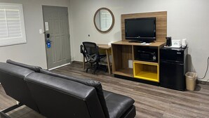 A modern office space with a desk, chair, television, coffee machine, and a trash bin. - Days Inn by Wyndham El Centro (El Centro)