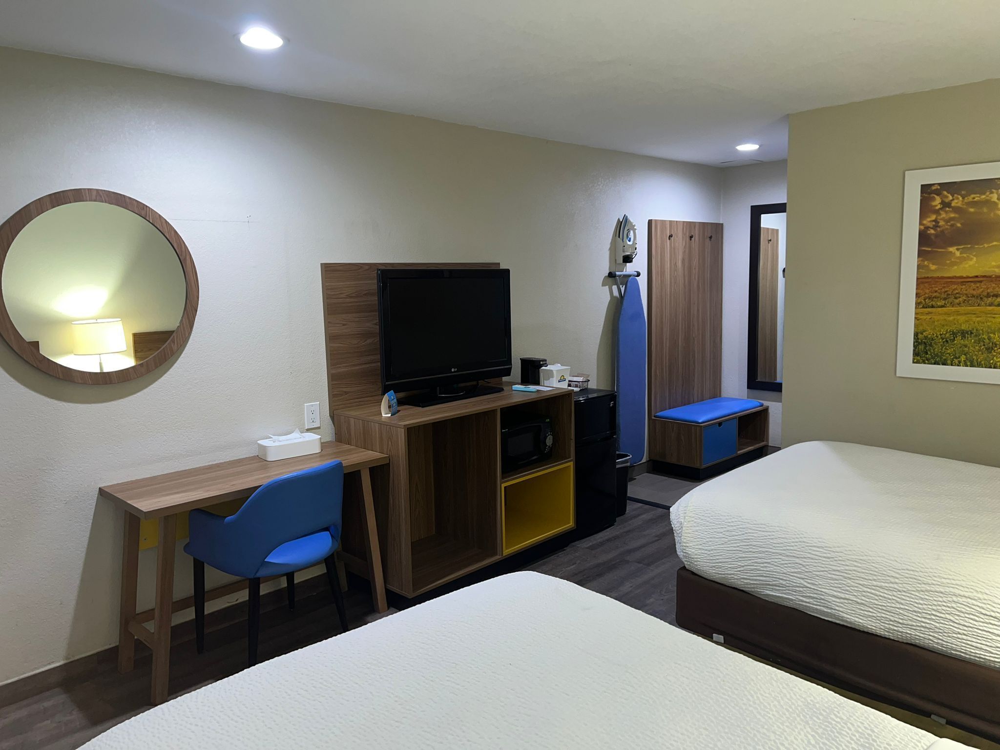 Une chambre d’hôtel équipée d’un bureau, d’une télévision, d’un lit et d’un miroir.