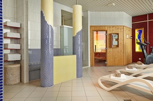 Un moderno espacio de spa con sauna, equipo de ejercicio y toallas ordenadas.