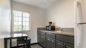 A compact kitchen with a window, a microwave, and a refrigerator. - Studio 6 Rosemead, CA – Pasadena (Rosemead)