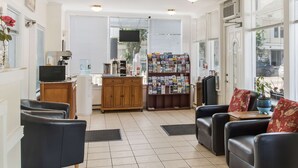 A spacious living area with a kitchen, a coffee machine, a television, and a magazine rack. - Americas Best Value Inn & Suites Hyannis Cape Cod (Hyannis)