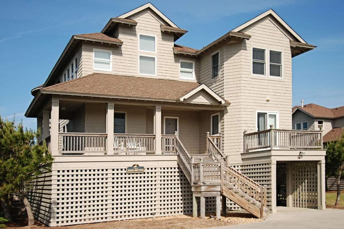 Une maison à deux étages avec un balcon et une véranda couverte.