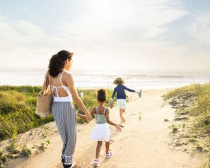 A pathway leading to a beach with people walking.