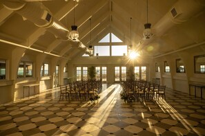 A large hall with a checkered floor, high ceilings, and large windows allowing natural light.
