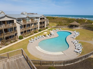 A resort with a large pool, multiple balconies, and ocean views.