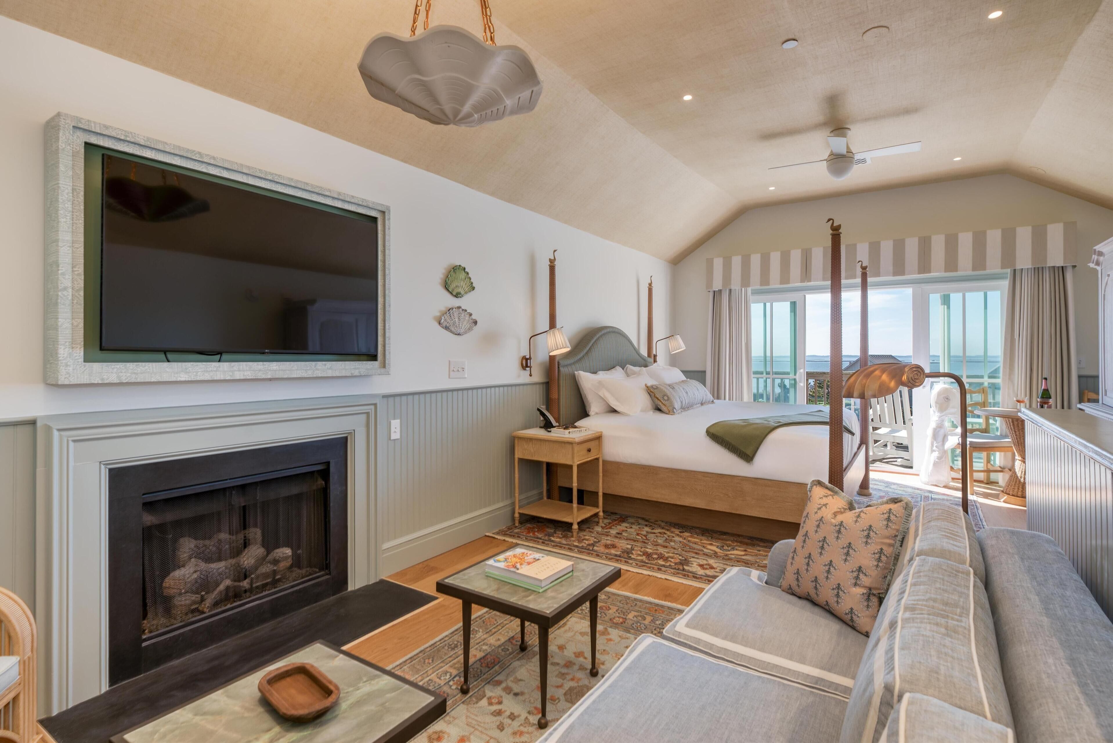 Un salón amplio con chimenea, un televisor de pantalla plana grande, un sofá confortable y un balcón con vistas.