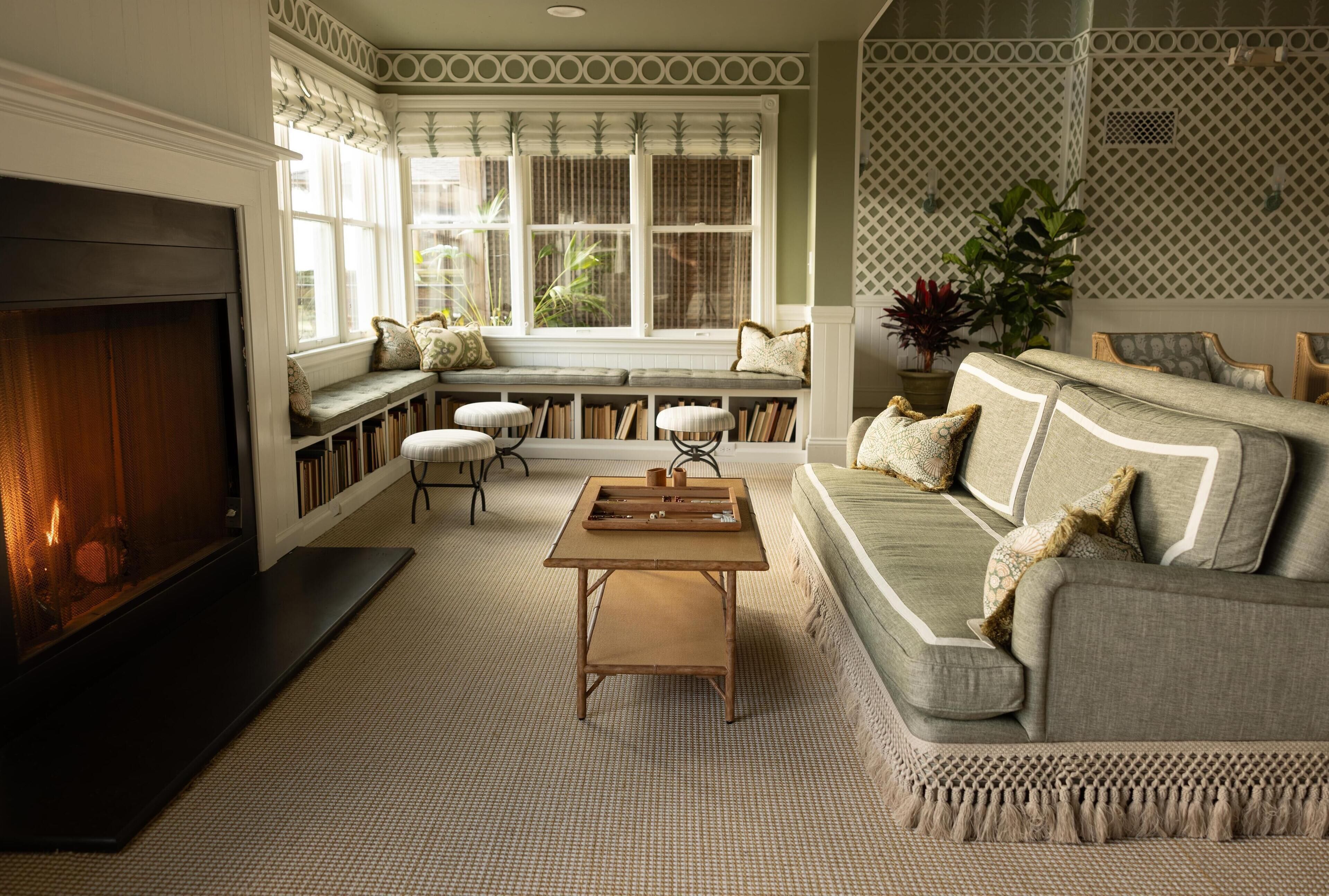 A cozy living room with a fireplace, a sofa, a bench, and a table.
