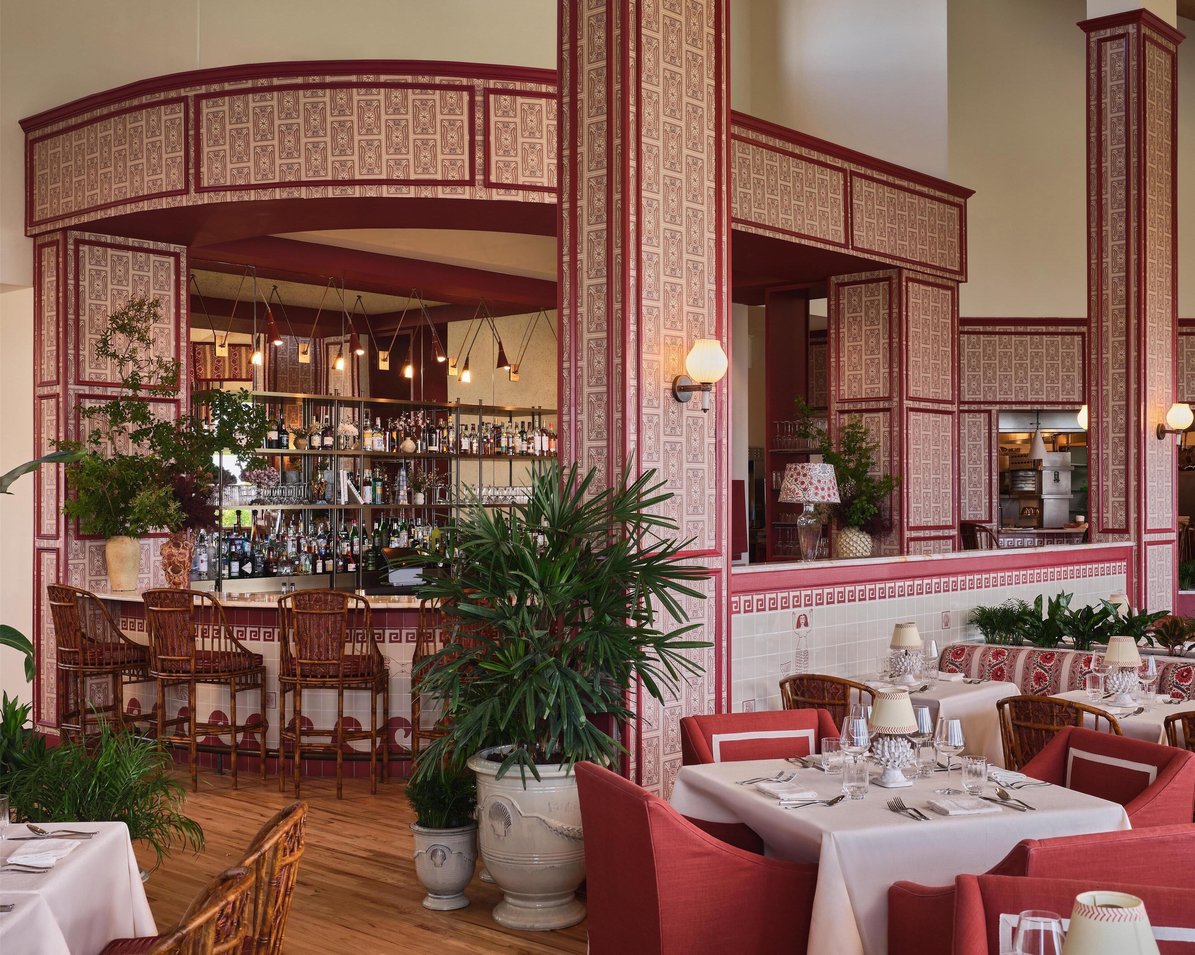 A restaurant with a bar area, multiple seating options, and decorative wall patterns.