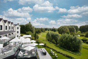 A rooftop terrace with outdoor seating and a view of a golf course. - Best Western Plus Le Fairway Hotel & Spa Golf d'Arras (Anzin-Saint-Aubin)