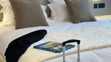 Ett hotellrum med en väl bäddad säng, en bok och en resväska.