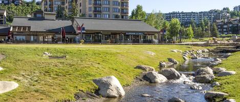 A riverside view with a restaurant and multi-story buildings in the background.