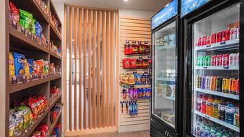 A snack and beverage vending area with various snack bags and bottled drinks.