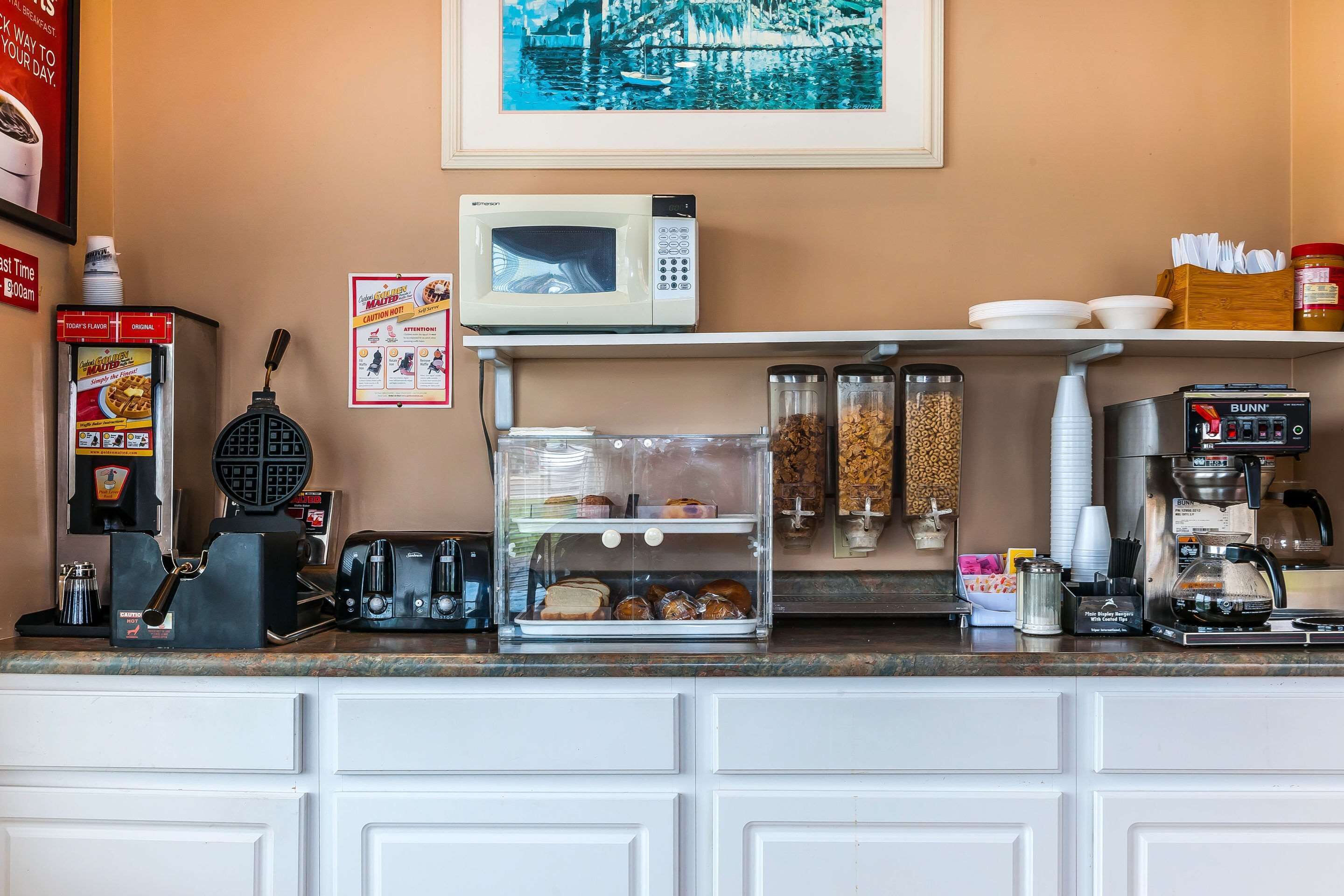 A kitchen counter with a microwave, toaster, coffee machine, and various food items.