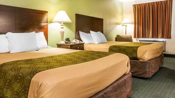 Ett hotellrum med två sängar, var och en med en sänggavel, sängbord, lampor och en telefon.
