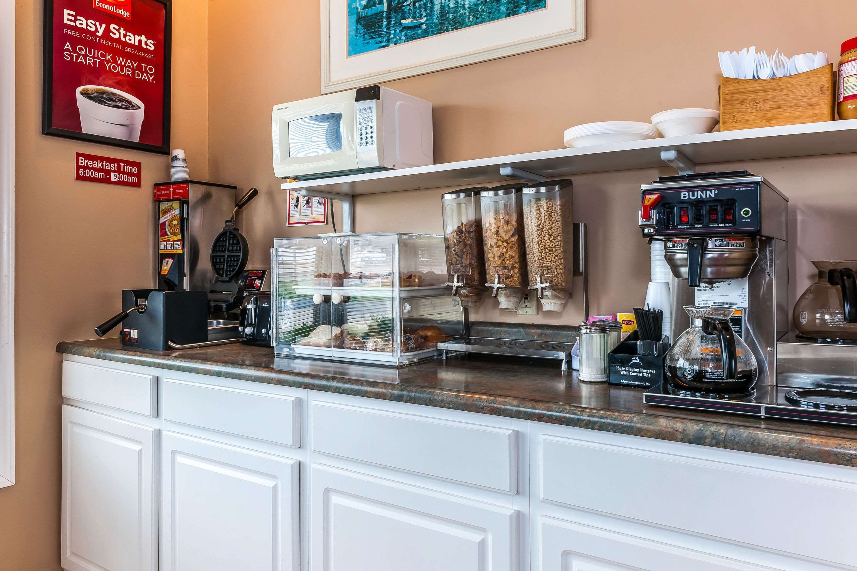 Een ontbijtruimte met een magnetron, koffieapparaat en automaten voor eten.