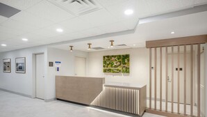 A modern reception area with a reception desk, a vertical garden, and a wooden partition. - Best Western River Cities (Russell)